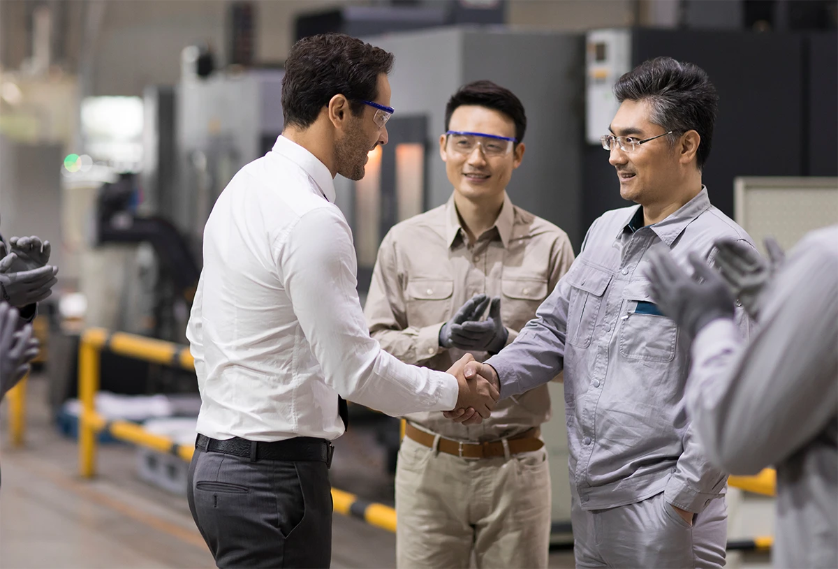 Manufacturing employees shaking hands