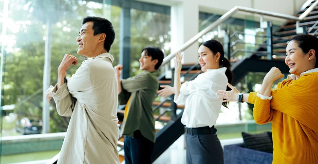 Employees doing a stretching routine in an office