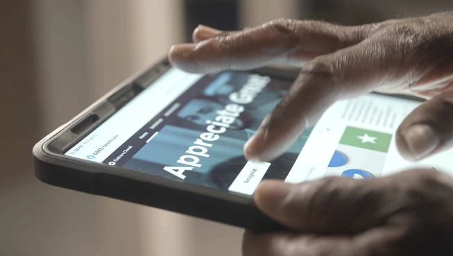 An employee giving recognition on an iPad from O.C. Tanner's recognition software.