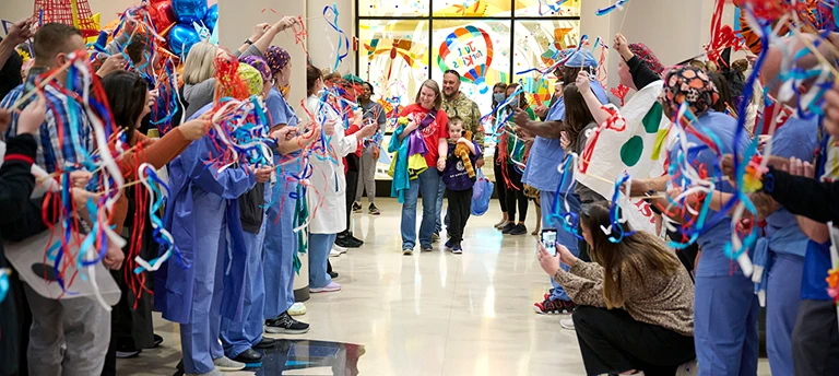 Des professionnels de santé fêtent le départ d'une famille d'un établissement hospitalier.