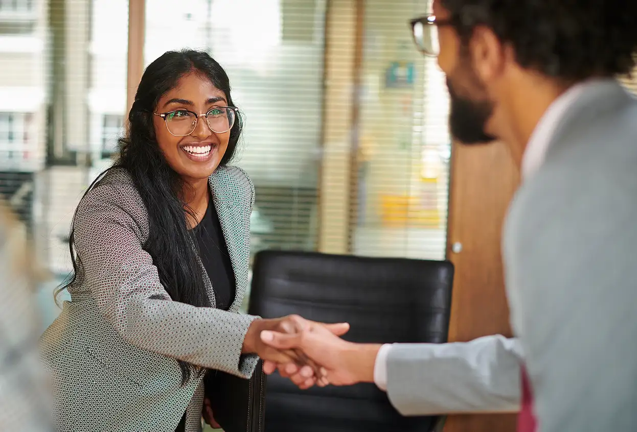 Two employees shake hands