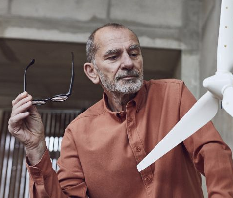 Employee in an office looking at a wind turbine model