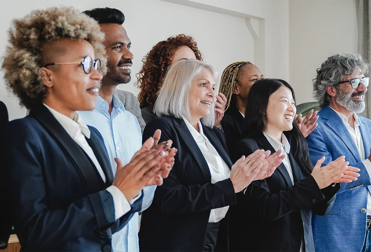 Employees in a meeting clapping and celebrating