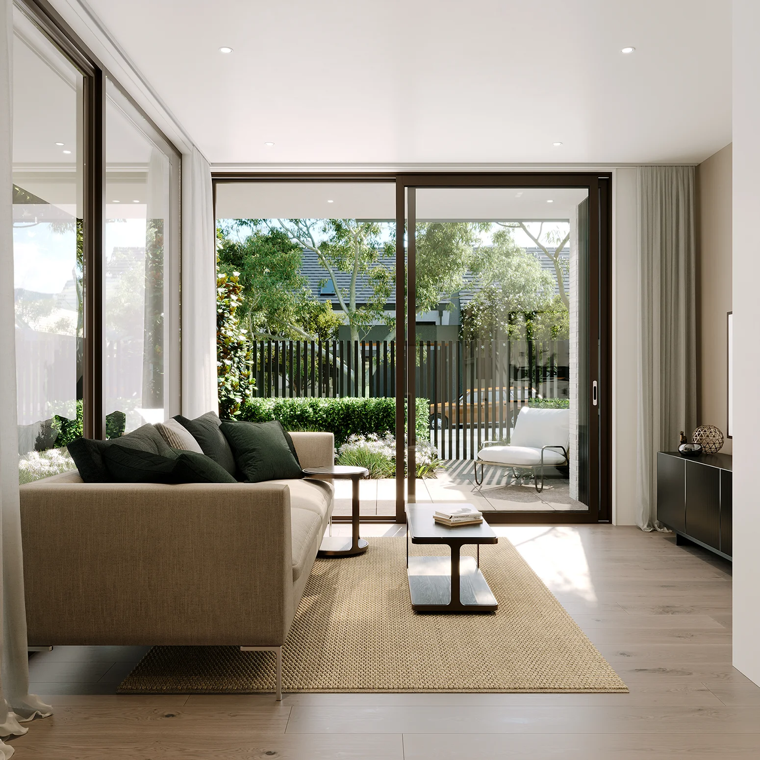 Modern living room with beige sofa, dark green pillows, wooden coffee tables, and large sliding glass doors.