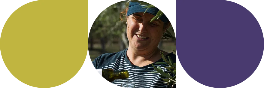 Woman wearing a visor and striped shirt smiling while pouring olive oil into a glass outdoors.