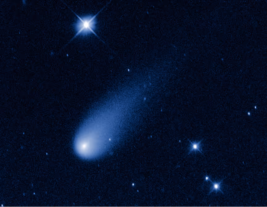 Bright comet with glowing nucleus and a diffuse tail against a starry night sky.