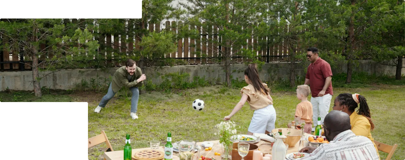 Smiling couple sitting on the front steps of their house, holding hands.