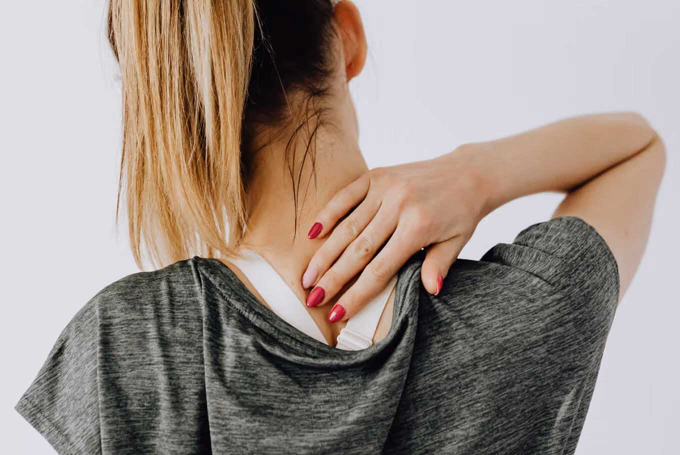 Woman experiencing neck pain and discomfort representing common conditions treated with chiropractic care