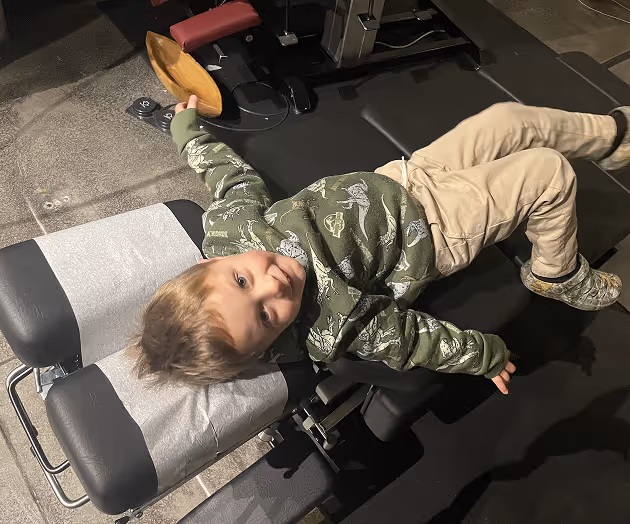 Chiropractor performing gentle pediatric adjustment on young patient in Fayetteville AR office