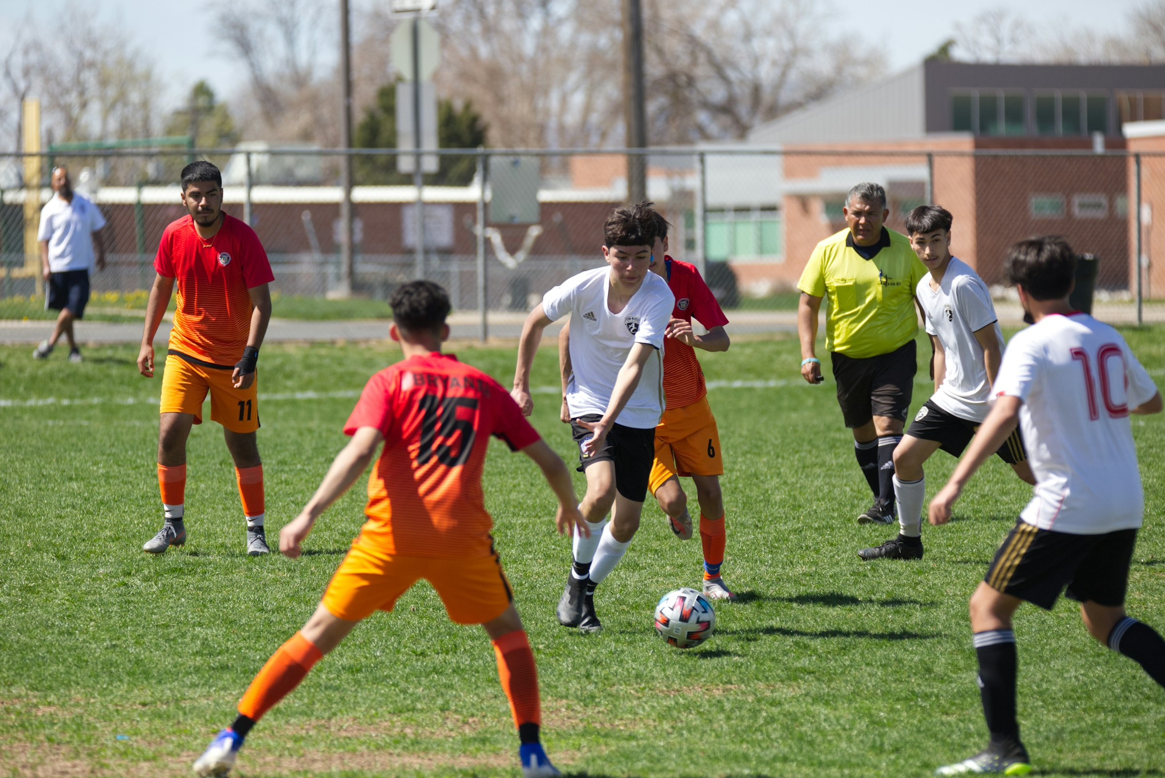 Young football players competing in a youth match, focusing on footwork and close ball control on a grass field.