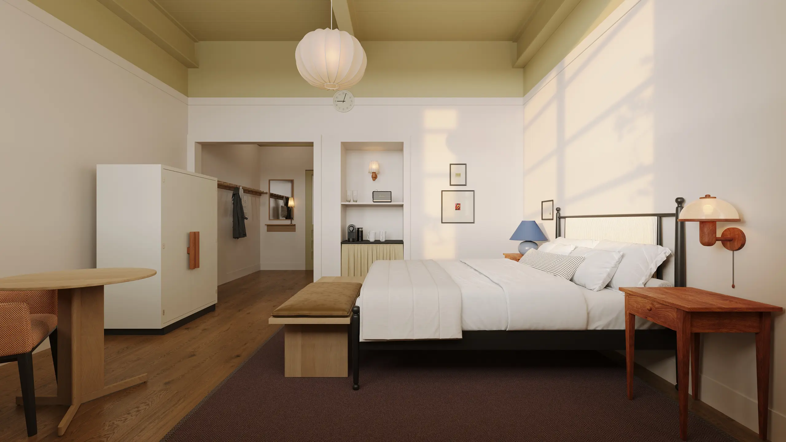Minimalist bedroom with a large bed, wooden side tables, bench, hanging lamp, and soft natural light casting shadows on white walls.