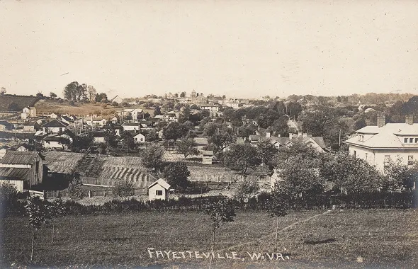 Black and white panoramic view of Fayetteville, West Virginia, showing houses, trees, and farmland.