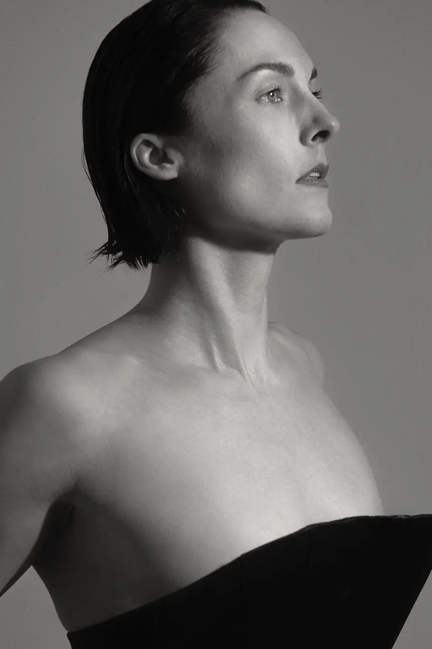 Woman in strapless black top looking upward