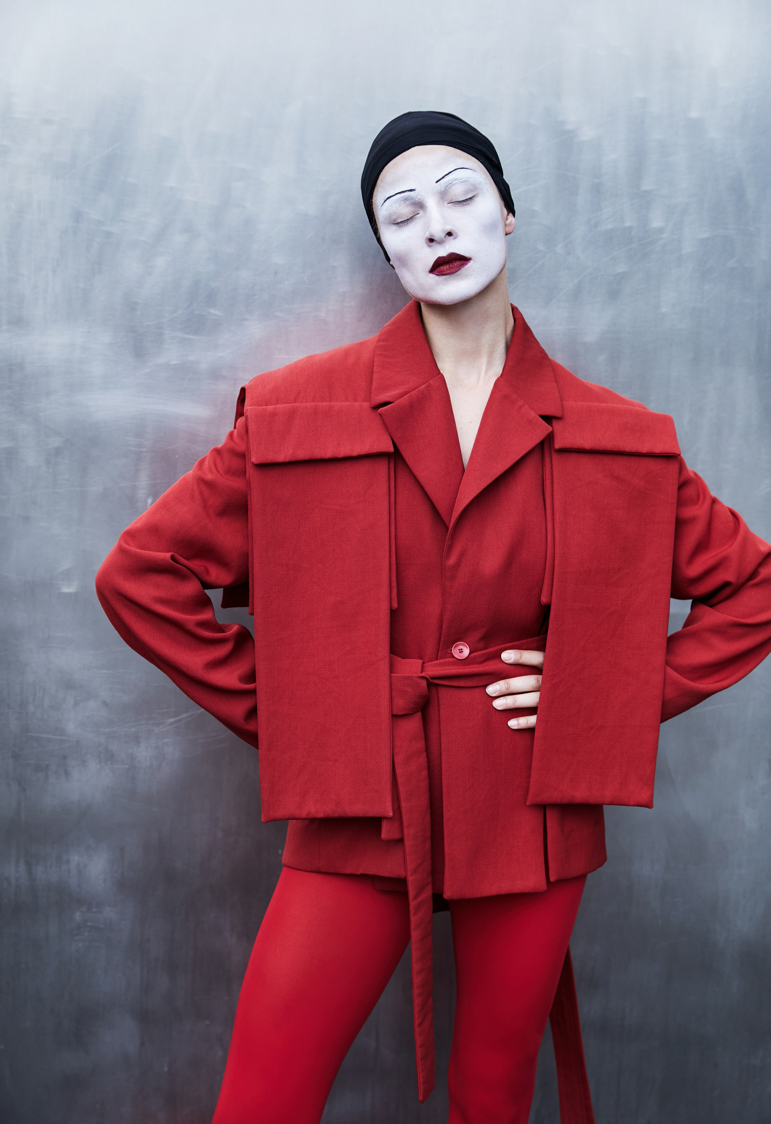 women in red costume with white make up looking to the camera.