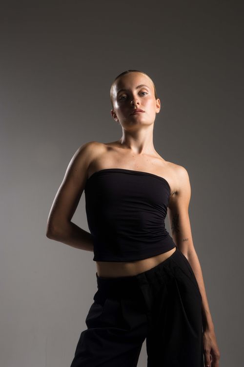 Woman in dark sleeveless top in studio sanding strong