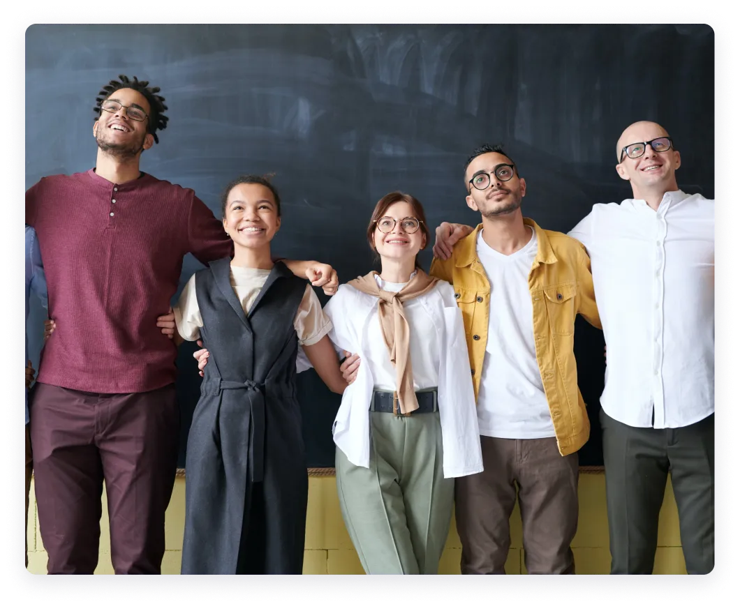 Five diverse individuals standing together and smiling in front of a dark background.