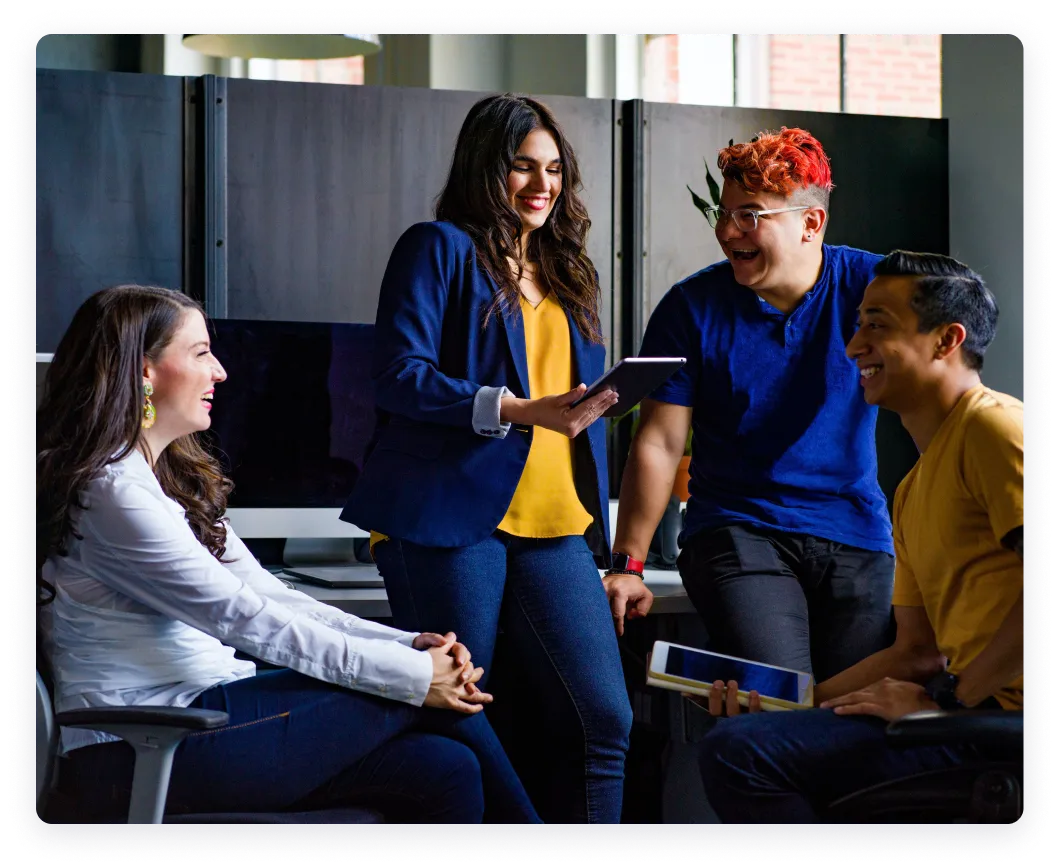 The image shows a top-down view of a pregnant person working on a laptop. The person is seated on a comfortable couch or daybed with light-colored cushions.