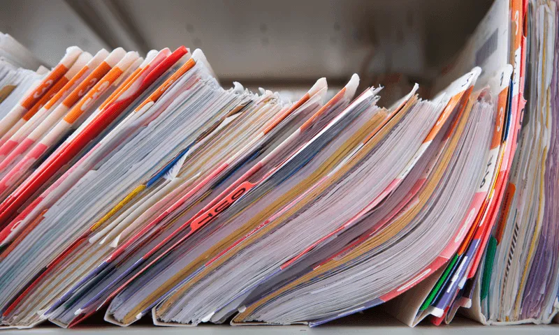 Shelf stacked with medical records.
