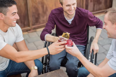 Man in wheelchair celebrating with friends