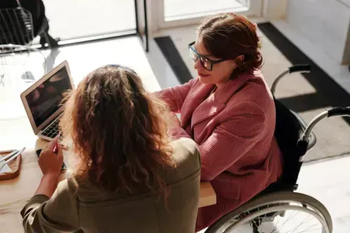 People gathered in an office around a person in a wheelchair