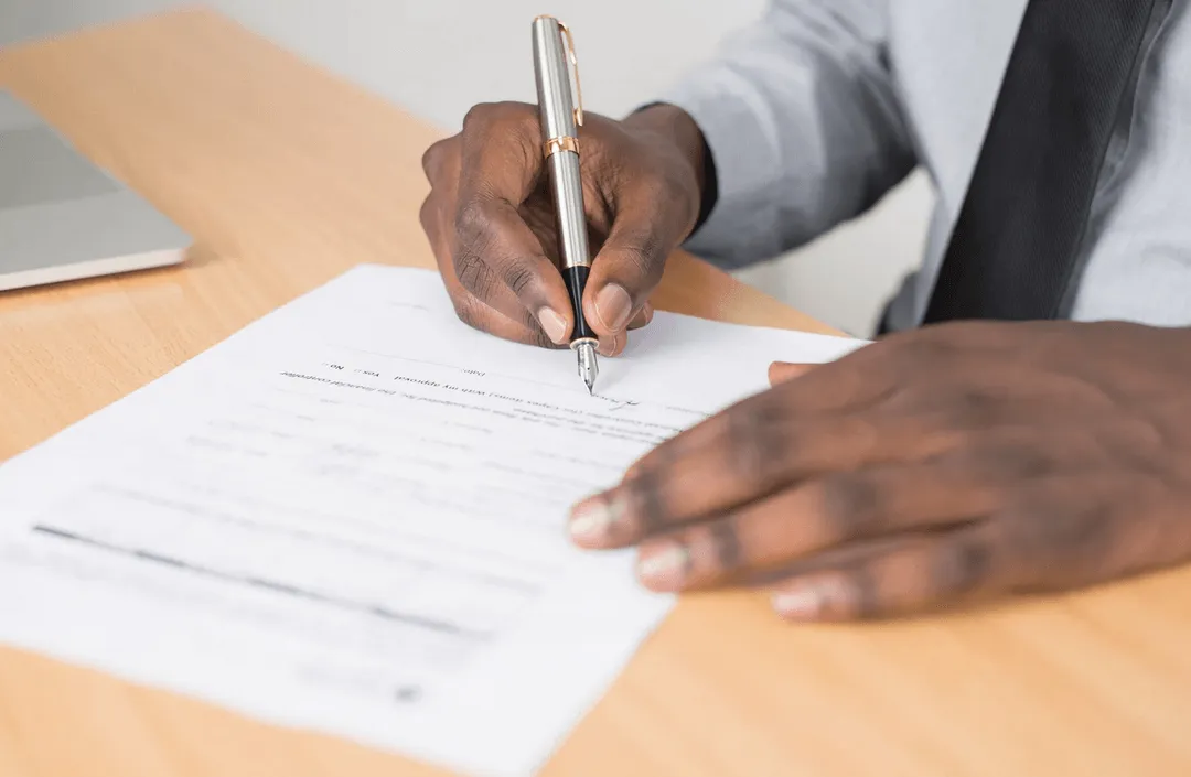 A person signing a form.