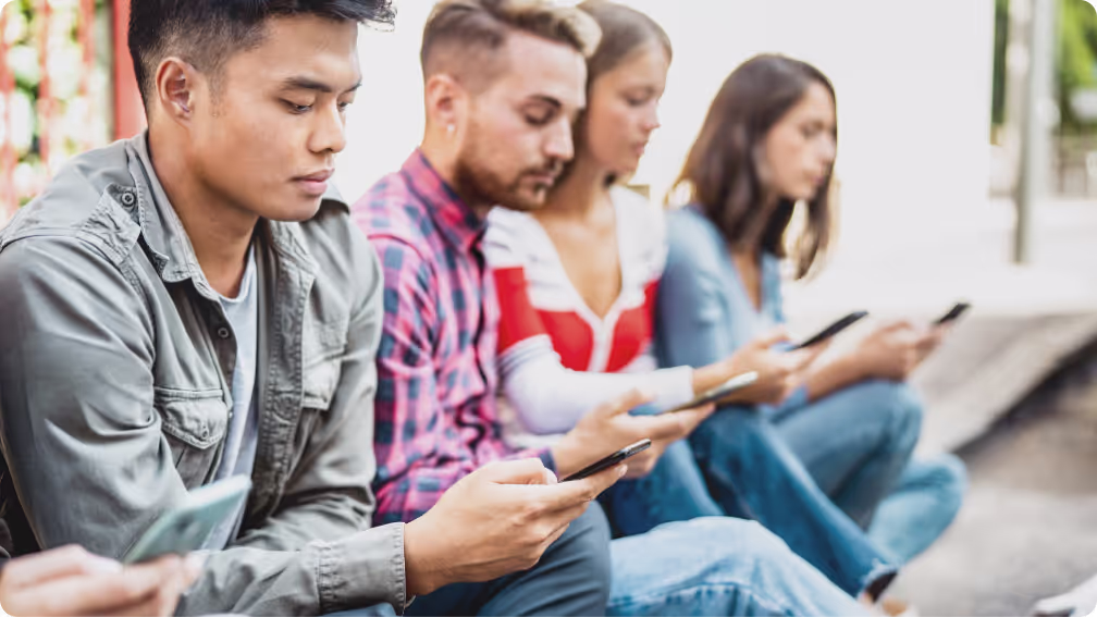 Group of young people looking at their phones.