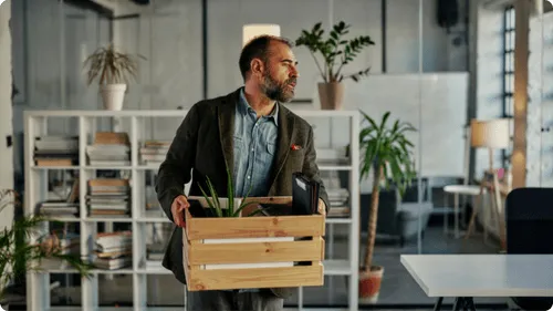 A person walking into their office with their belongings looking confused.