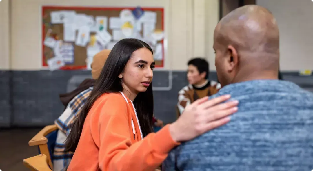 A person patting someone on the shoulder