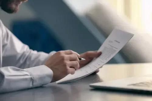 Image of someone reviewing documents at a desk.