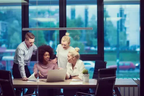 Group of people looking over a computer.