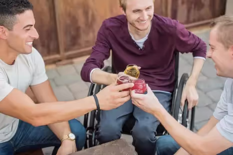 Man in wheelchair celebrating with friends