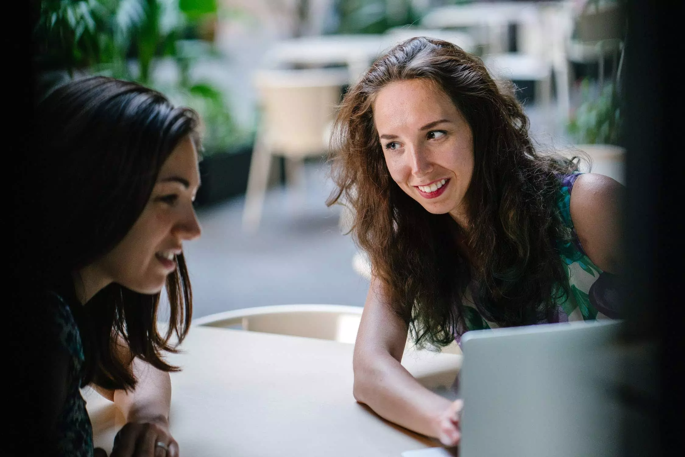 Two women looking at laptop screen.