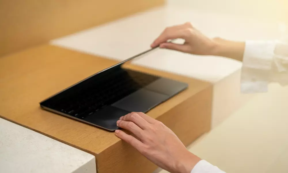 Woman's hands shutting a laptop
