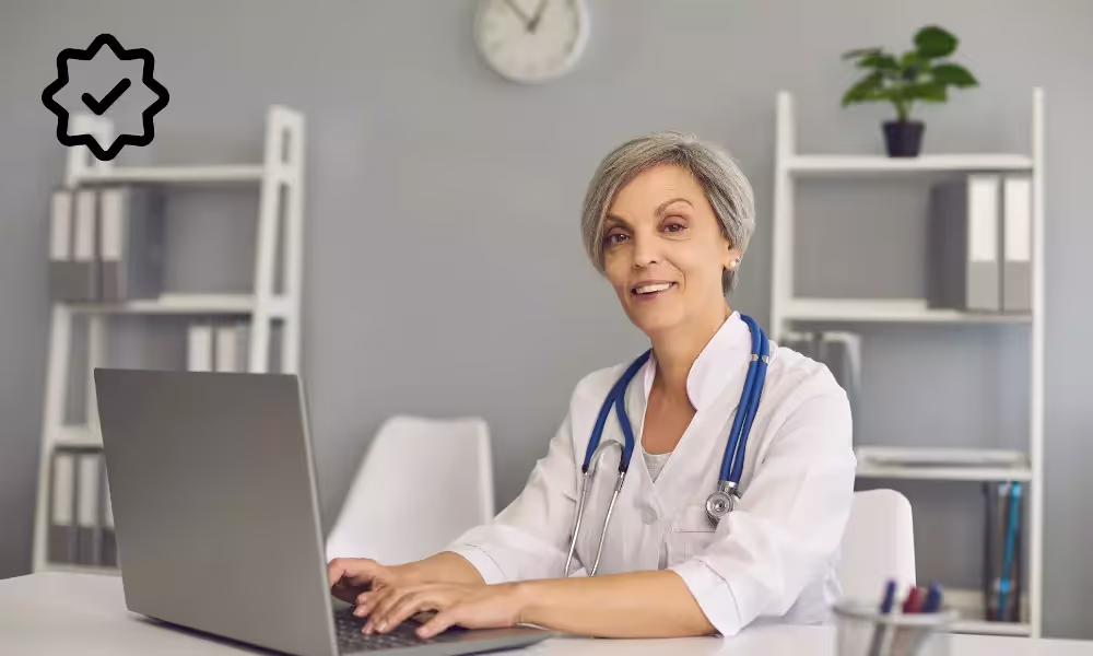 Female doctor working on laptop. In the left corner is a Disclo verified symbol.