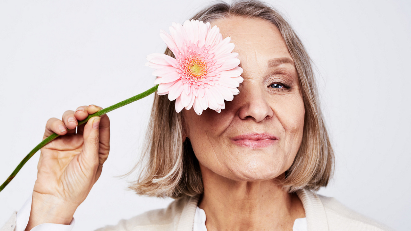 Older person holding a flower.