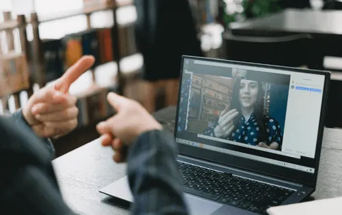 Two people using sign langauge on a video call.
