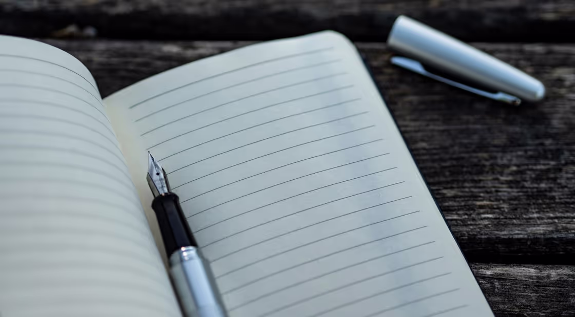 Photo of a notebook and pen.