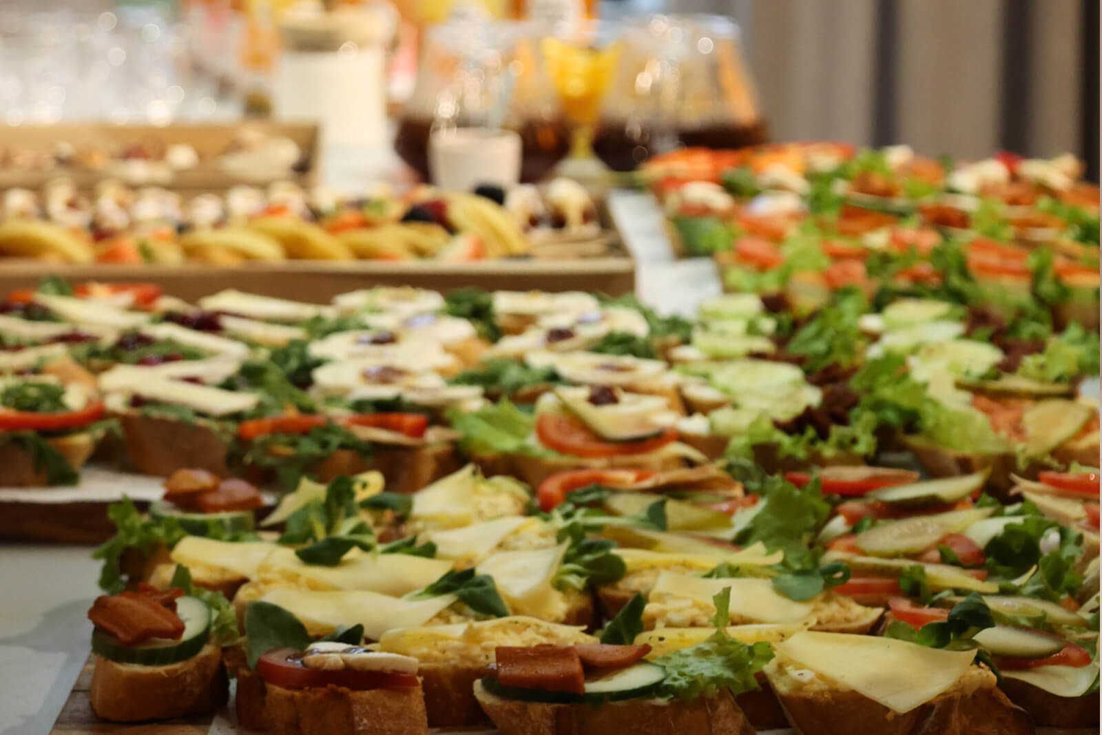 Zdjęcie przedstawia stół na którym znajduj się kanapki i napoje.