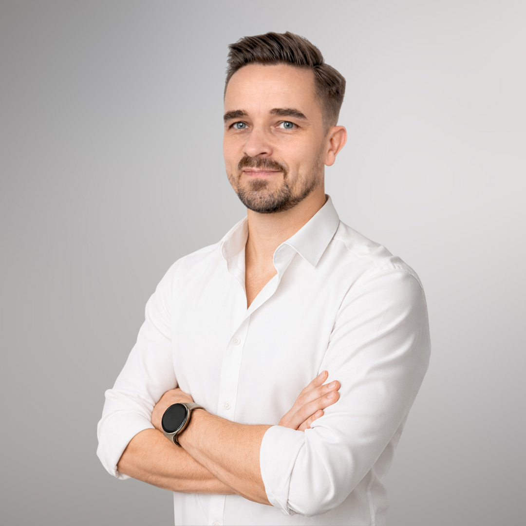 Zdjęcie przedstawia osobę odpowiedzialną za kontakt z uczestnikami oraz jednego z prowadzących Krzysztofa Żukowskiego. Krzysztof siedzi przy stole a na jego kolanach znajduje się nasz Senior Good Boy, piesek Stefan.