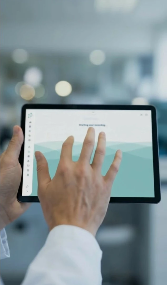 Hand eines Mannes berührt Tablet-Bildschirm mit der Anzeige 'Starting your recording'.