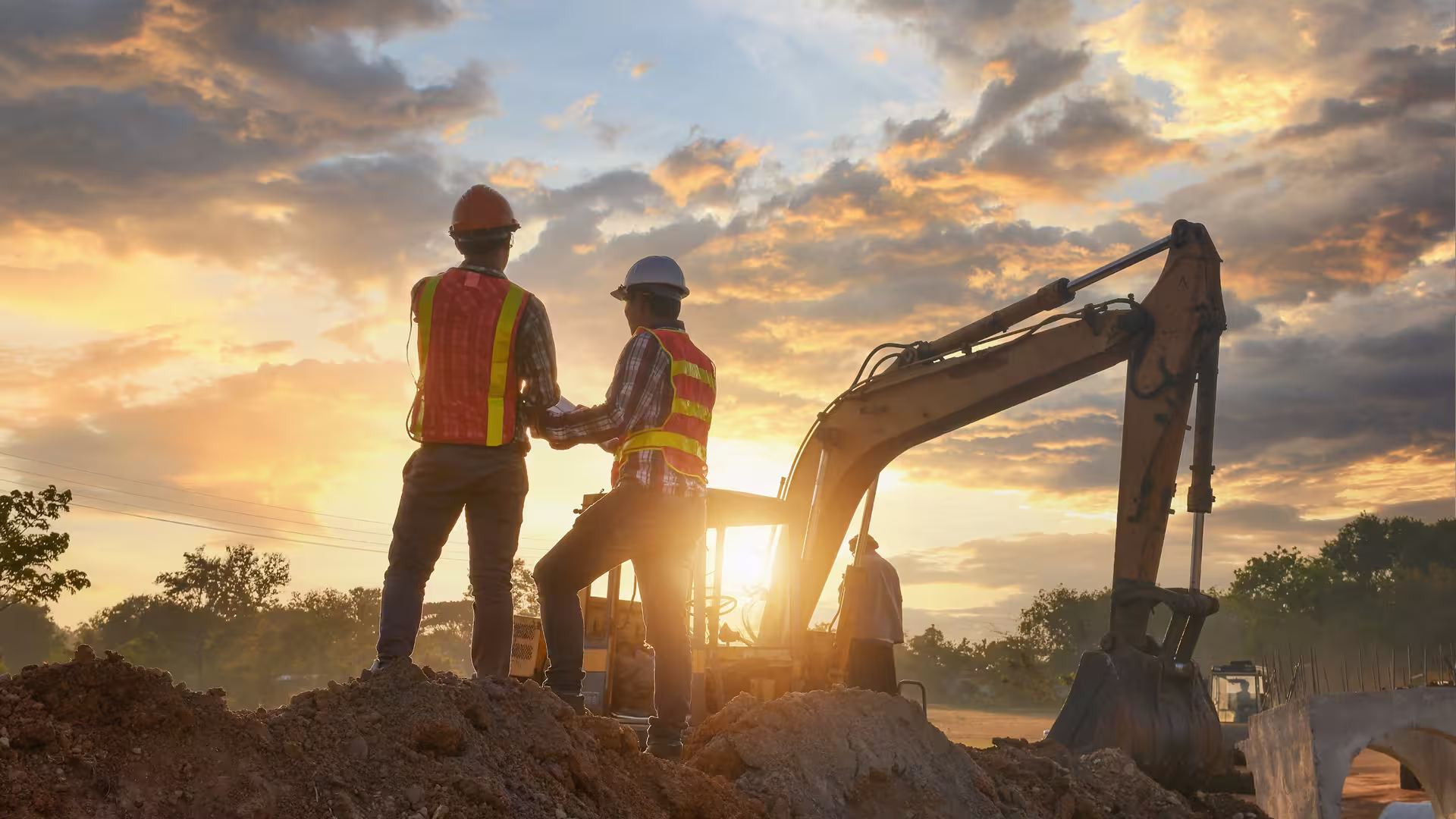 Two ABV Development workers on site at sunset — field expertise and soil remediation