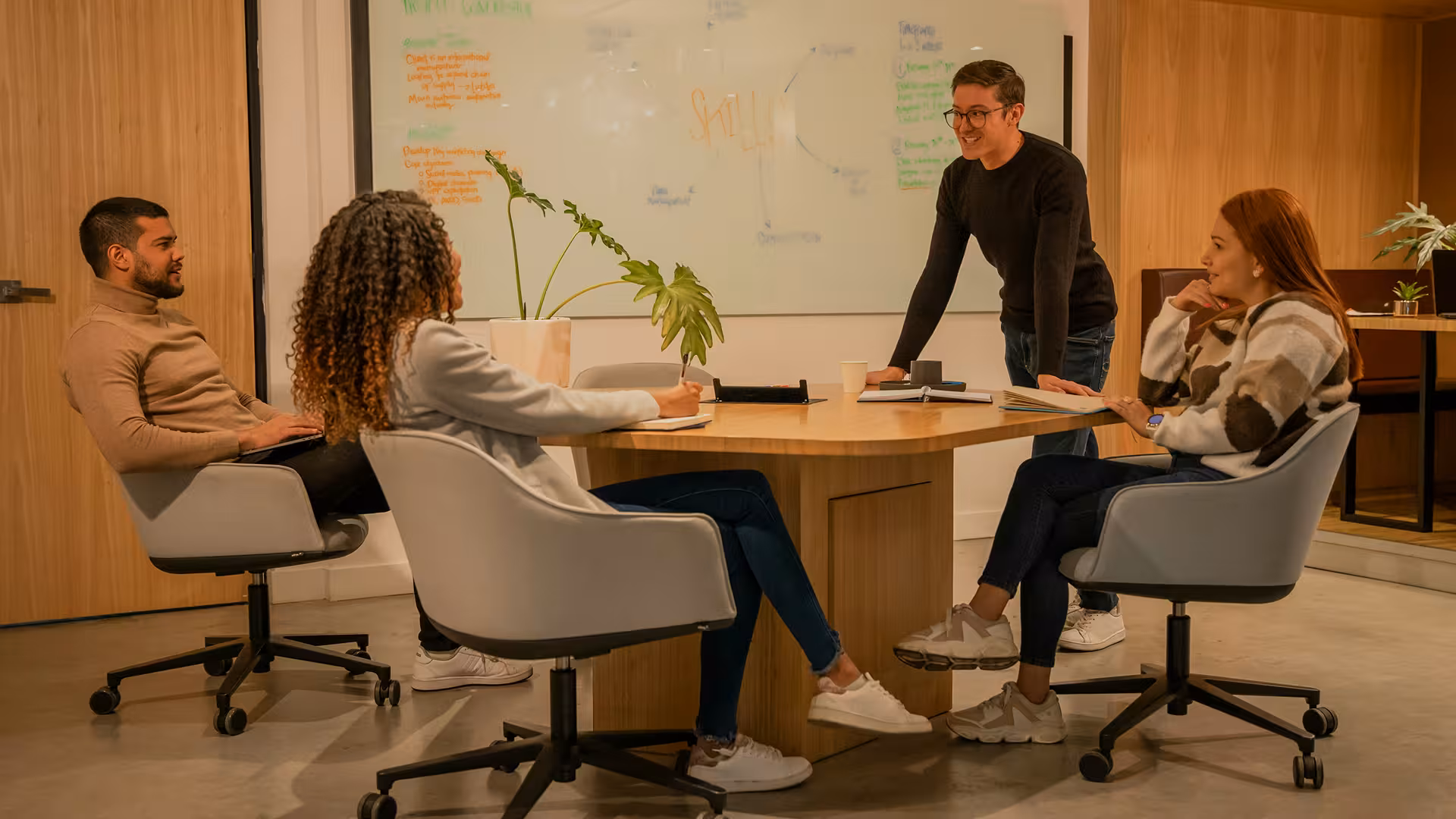 Réunion créative autour d'une table ronde devant un tableau, illustration pour Déductions pour revenus d'innovation (DRI)