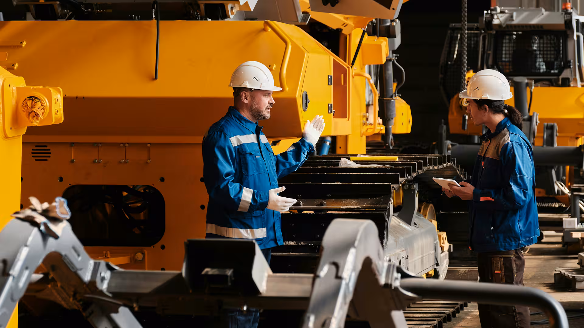Technicians operating yellow industrial machines