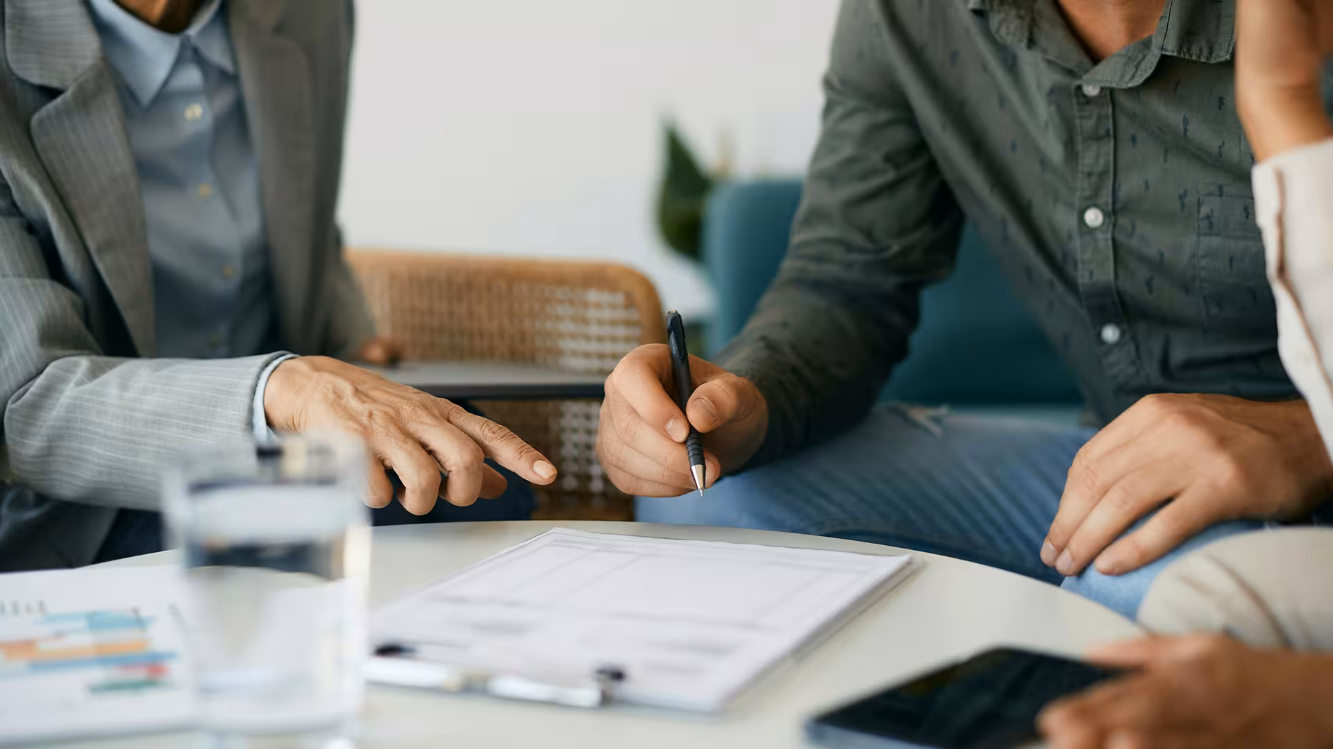 Personnes signant un document contractuel autour d'une table, illustration pour Évaluation environnementale