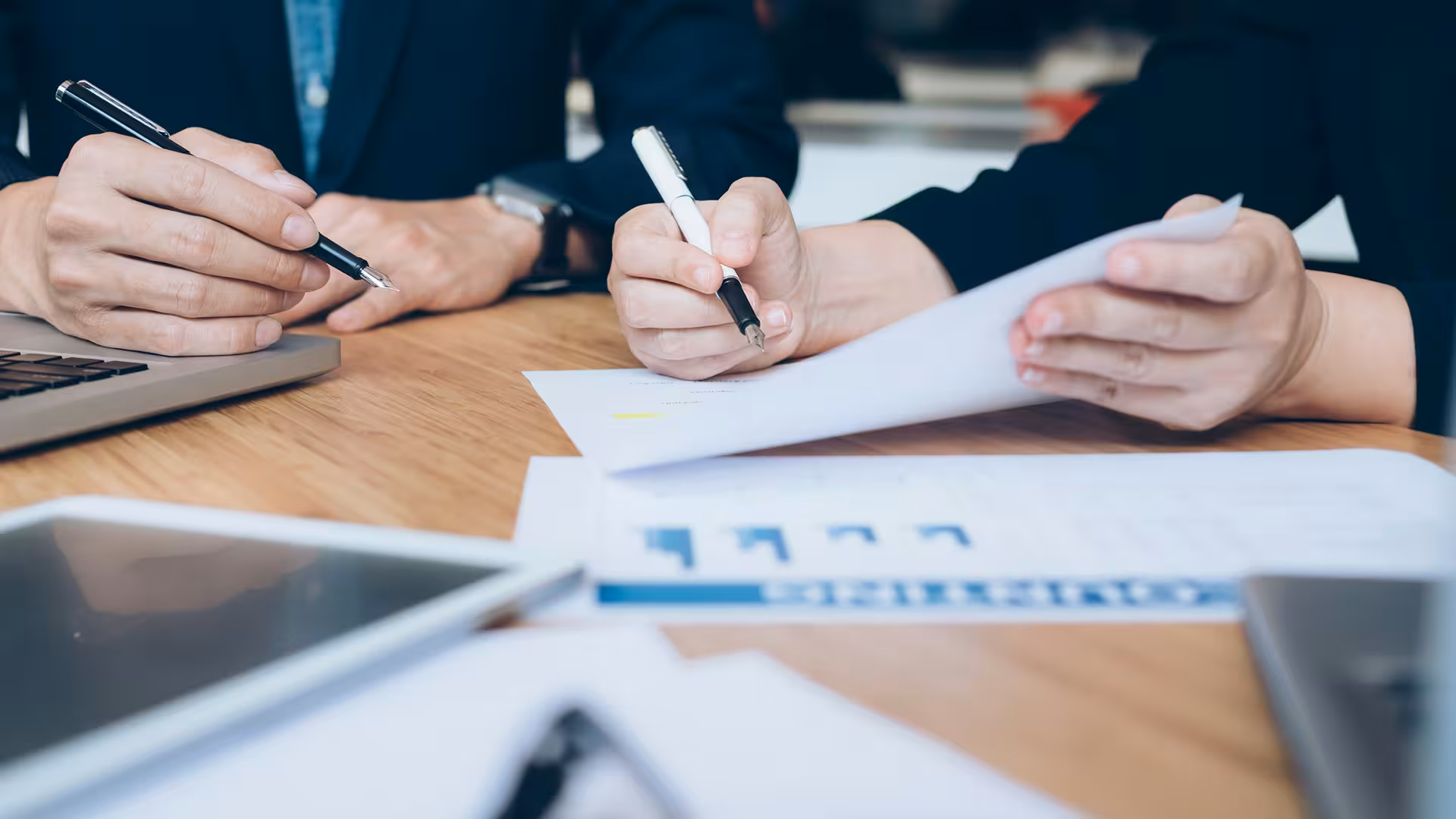 Mains feuilletant des documents de rapport sur un bureau, illustration pour Étude de faisabilité