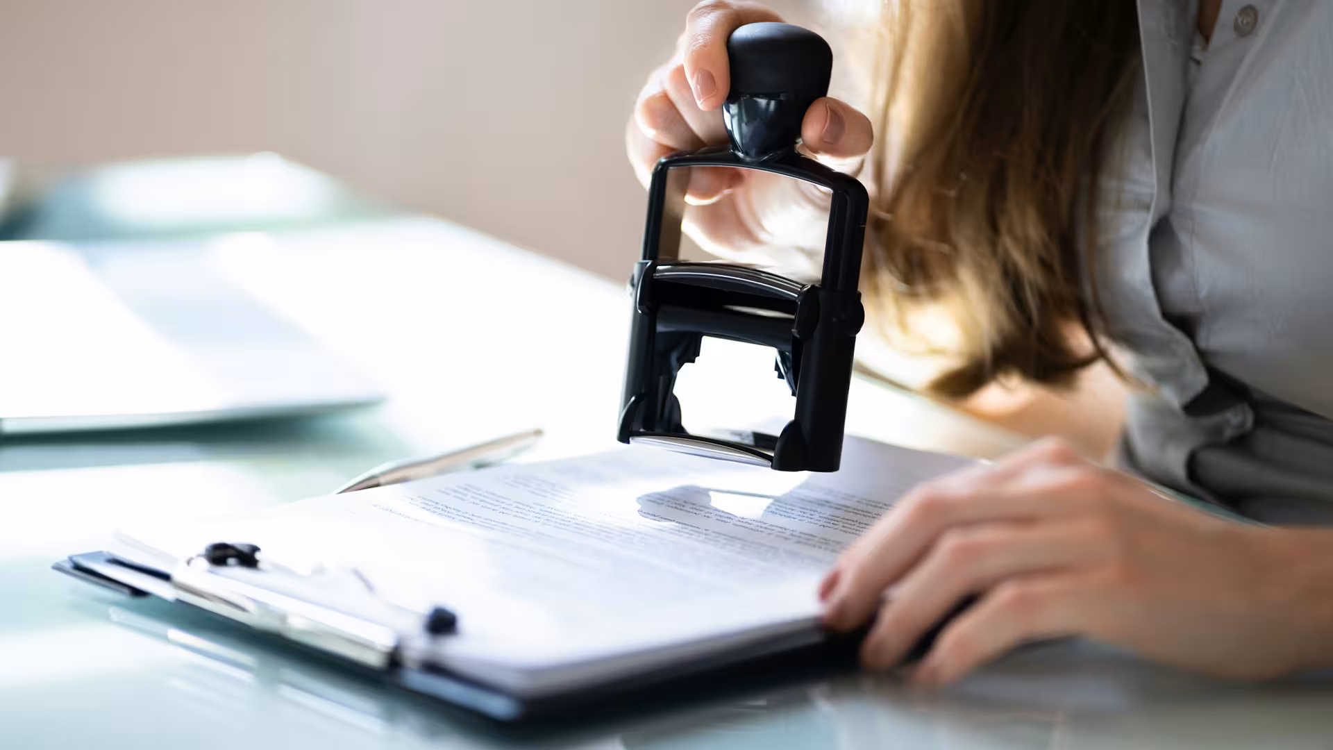 Femme apposant un tampon sur un document administratif, illustration pour Évaluation approprié et natura 2000
