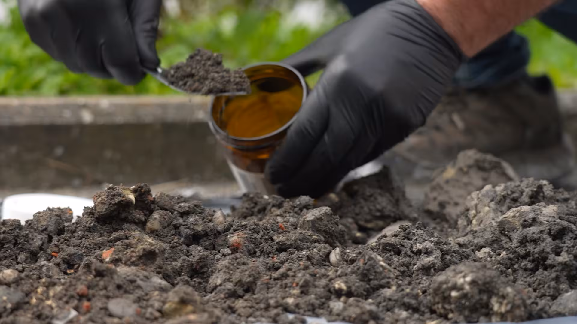 Gaunted hands taking a sample of potentially contaminated soil