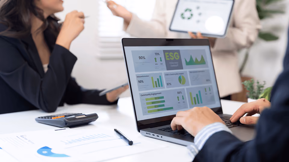 Personne travaillant sur un ordinateur portable affichant un tableau de bord ESG avec graphiques et statistiques.