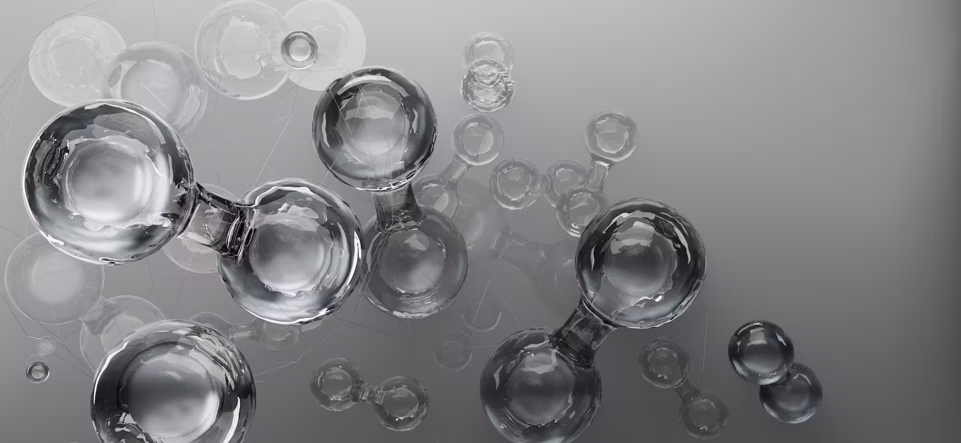 Représentation synthétique 3D de molécules d'eau ou de dihydrogène composées de sphères en verre transparent interconnectées.
