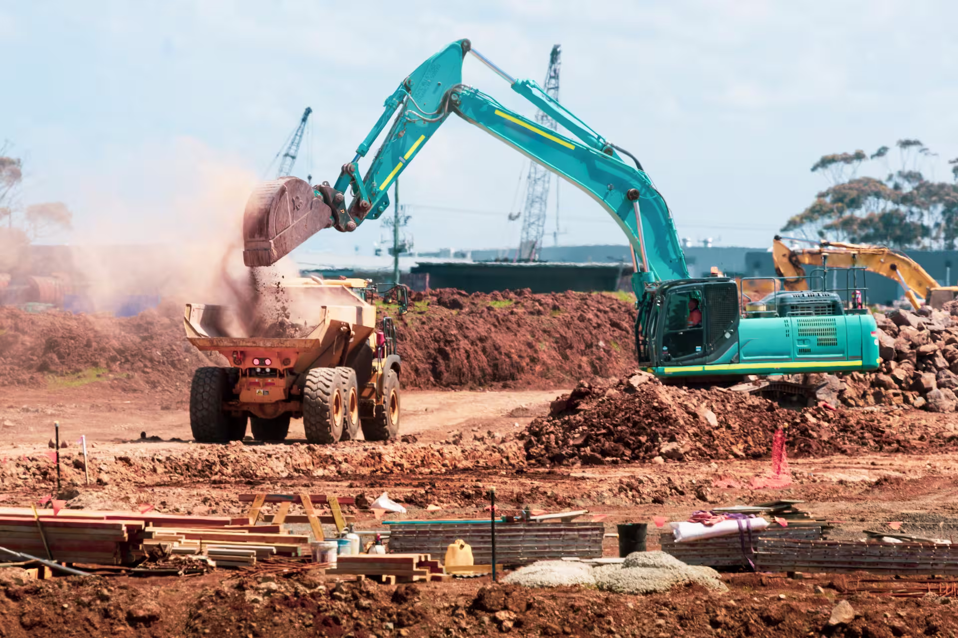 Quatre professionnels en réunion sur un chantier de construction dans un bâtiment en cours de réalisation.
